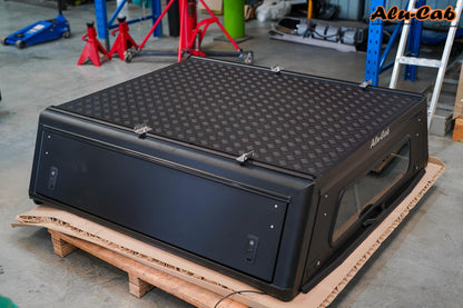 Hardtop Alu-Cab Explorer 3 en aluminium pour Mitsubishi L200 2016+, vue de face avec fenêtres et détails de montage.