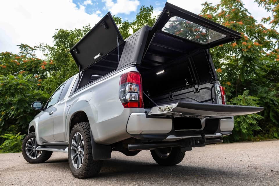 Hardtop Alu-Cab Explorer 3 en aluminium pour Mitsubishi L200 2016+, vue en extérieur avec fenêtres et porte latérale.