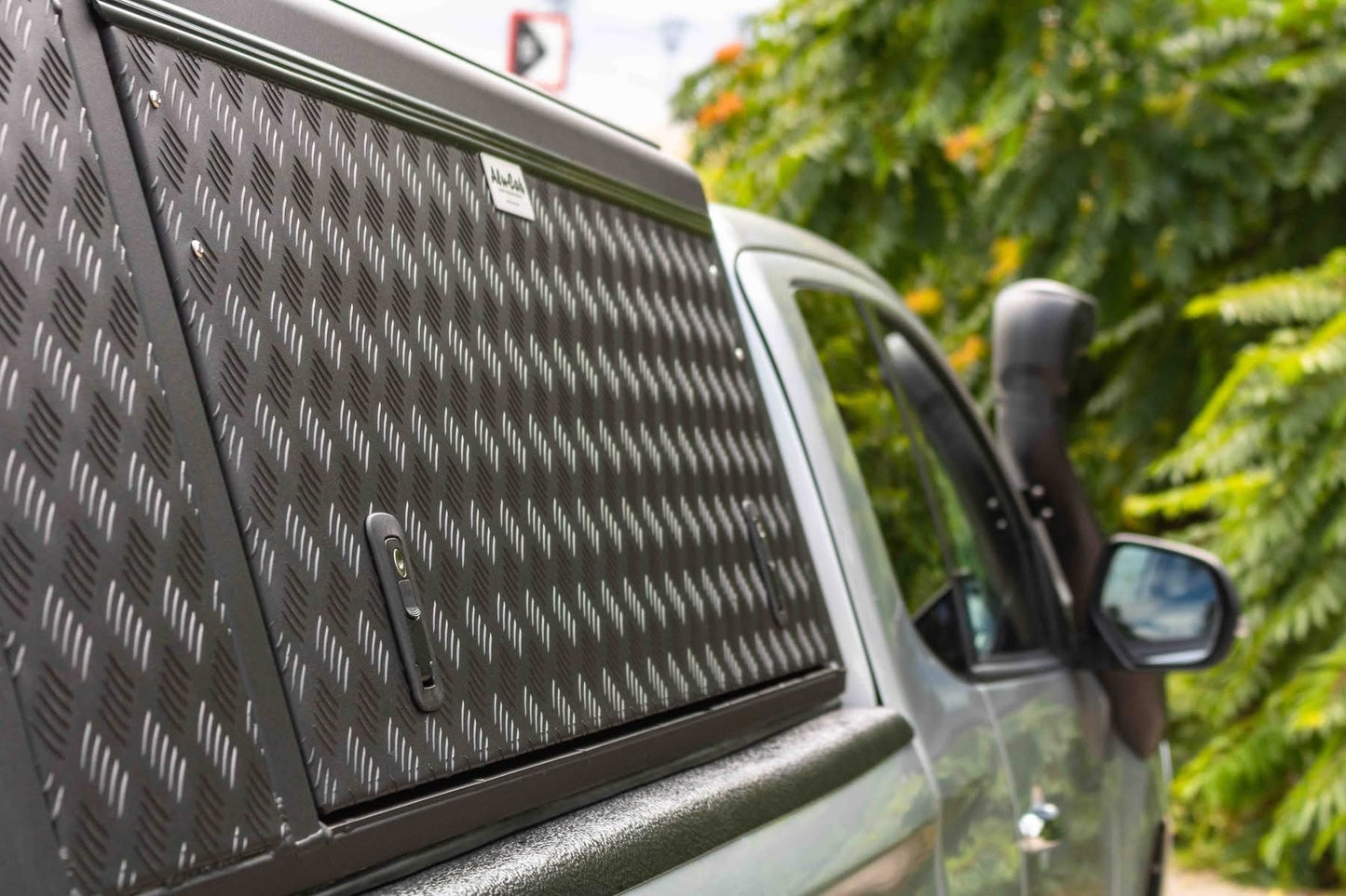 Hardtop Alu-Cab Explorer 3 en aluminium pour Mitsubishi L200 2016+, vue de côté avec fenêtre et fixation.