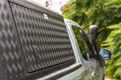 Hardtop Alu-Cab Explorer 3 en aluminium pour Mitsubishi L200 2016+, vue de côté avec fenêtre et fixation.