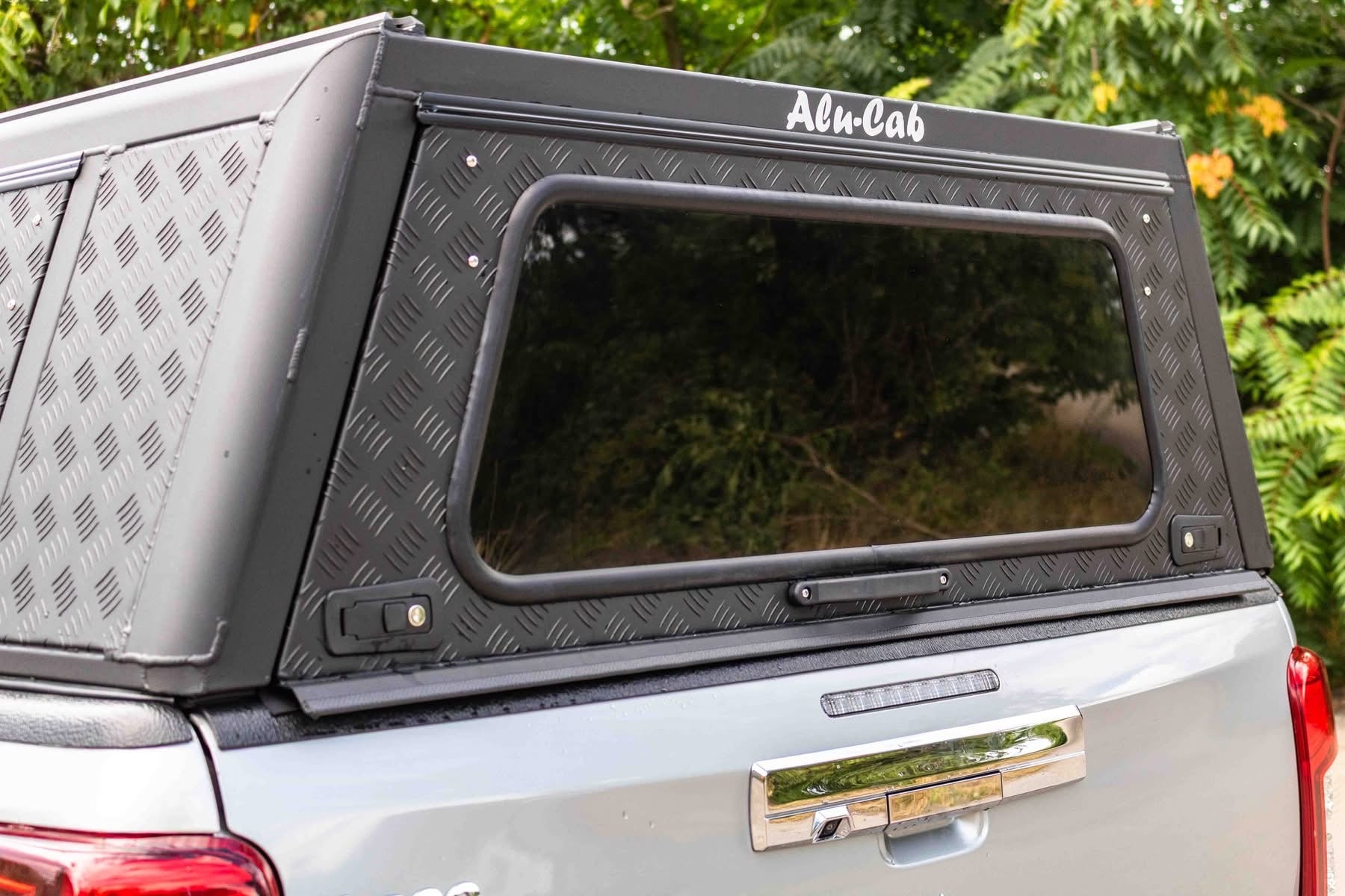 Hardtop Alu-Cab Explorer 3 pour Mitsubishi L200 2016+ en aluminium, vue du côté avec fenêtres et fixation.